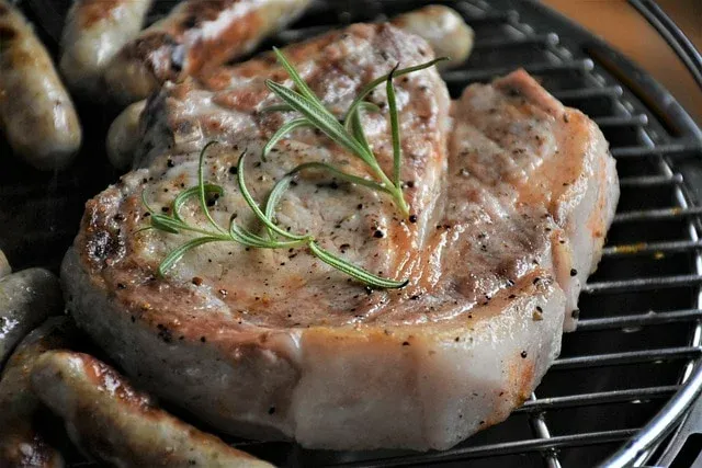 Grillowany kotlet wieprzowy z rozmarynem i kiełbaskami na ruszcie