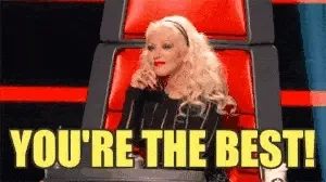 A talent-show judge in a red chair beside the words YOU'RE THE BEST