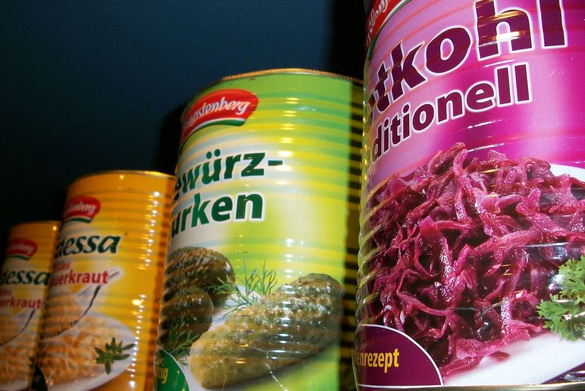 Reihe Konserven mit Rotkohl, Gurken und Sauerkraut, bunt etikettiert