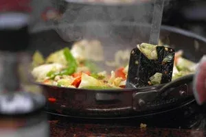 Légumes sautés dans un wok avec une spatule noire