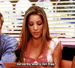Jeune femme au restaurant, avec la légende « no carbs, and is fat-free? »