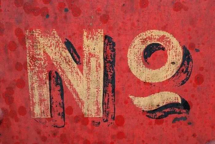 Lettres No peintes en beige et noir sur un fond rouge écaillé